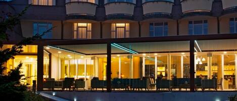 A hotel with a modern facade, large windows, and a well-lit interior.