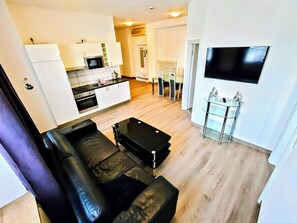 Habitación triple clásica | Zona de estar | Una televisión de pantalla plana