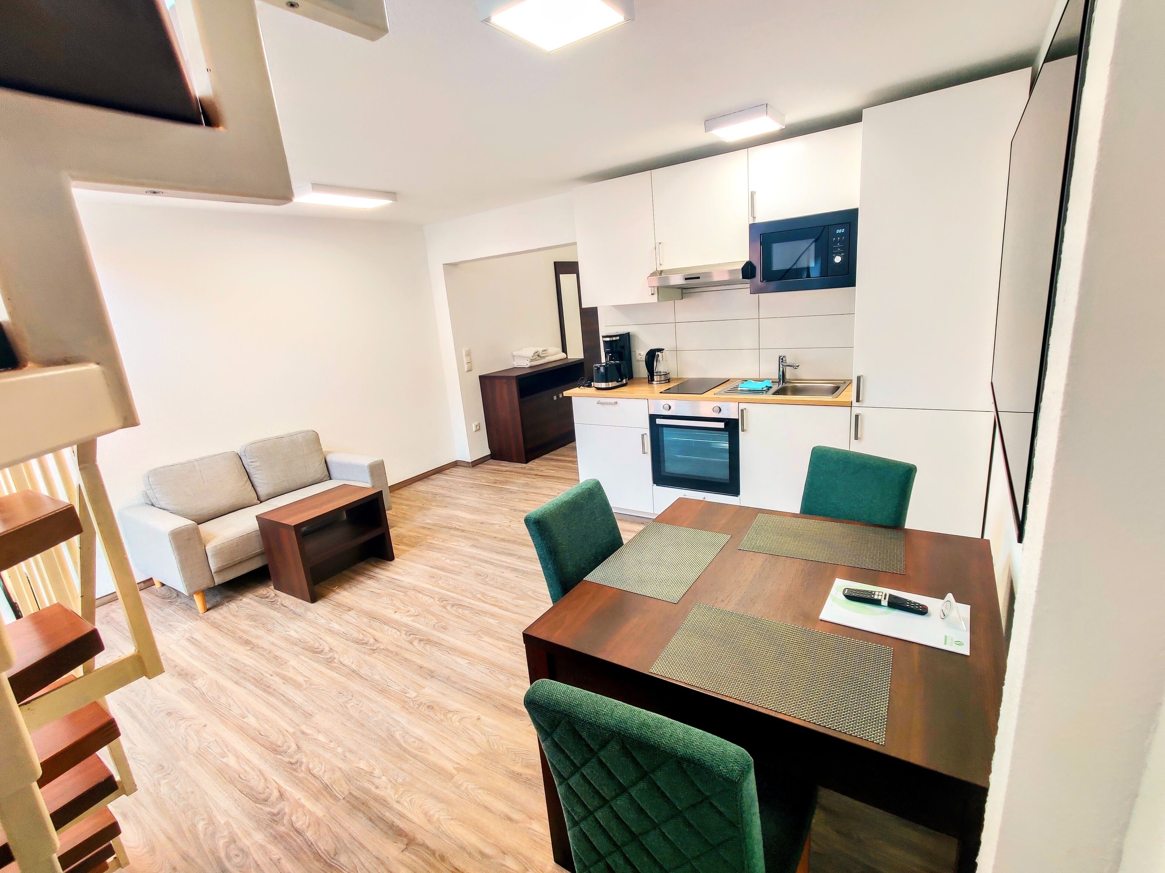 A compact living space with a kitchenette, a dining area, and a sofa.
