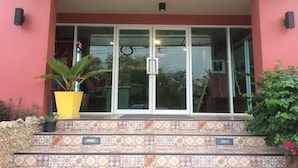 A building entrance with a tiled staircase, a potted plant, and a glass door. - Non Nid Non Noi Design Residence (Chiang Mai)