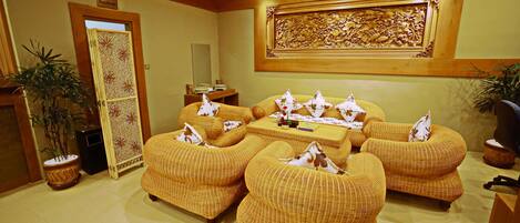 A room with a sofa set, a small table, and a decorative wall piece.