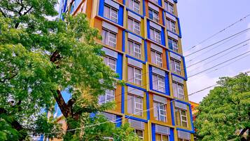 A multi-story hotel with a colorful facade, balconies, and a visible entrance.