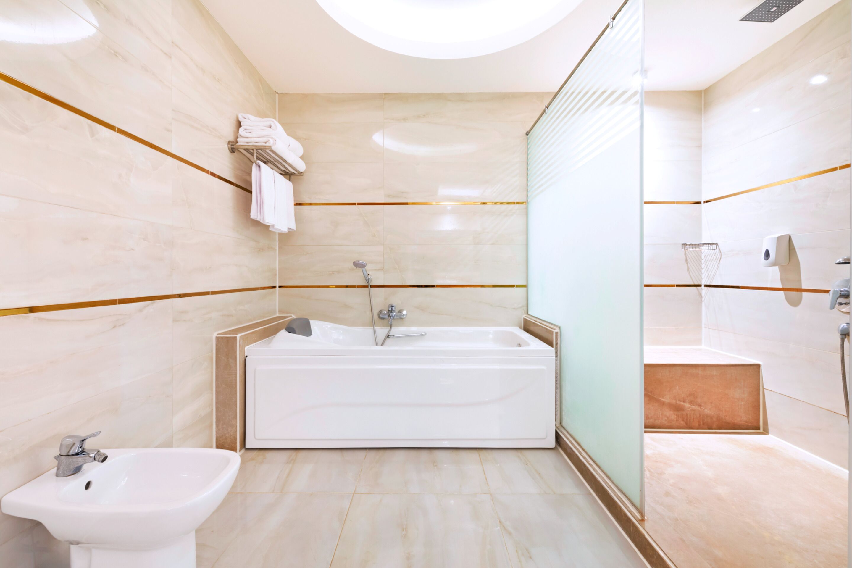 Un baño moderno con una bañera independiente, un lavabo y un box de ducha de vidrio.