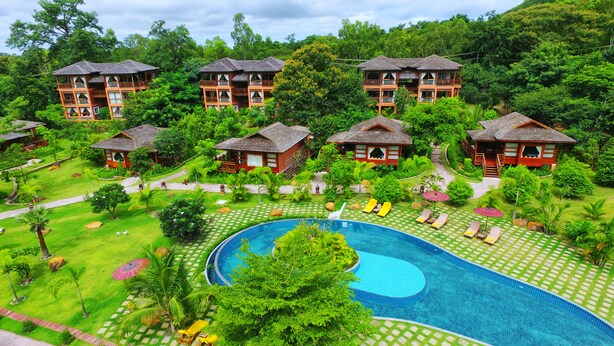 A resort with multiple wooden bungalows, a central swimming pool, and lush greenery. - Popa Garden Resort (Kyaukpadaung)