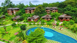 A resort with multiple wooden bungalows, a central swimming pool, and lush greenery. - Popa Garden Resort (Kyaukpadaung)