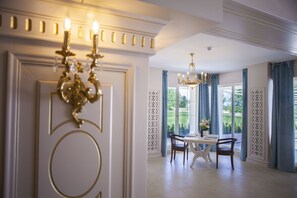 A dining area with a chandelier, a table, and chairs. - Hotel Sulina International (Constanta)