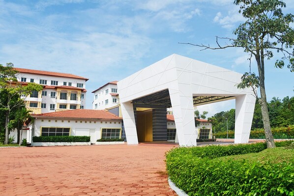 A modern building with a large entrance and a brick pathway leading to it. - Tiara Desaru Residences (Bandar Penawar)