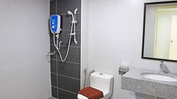 Un baño con ducha, inodoro, lavabo y espejo.