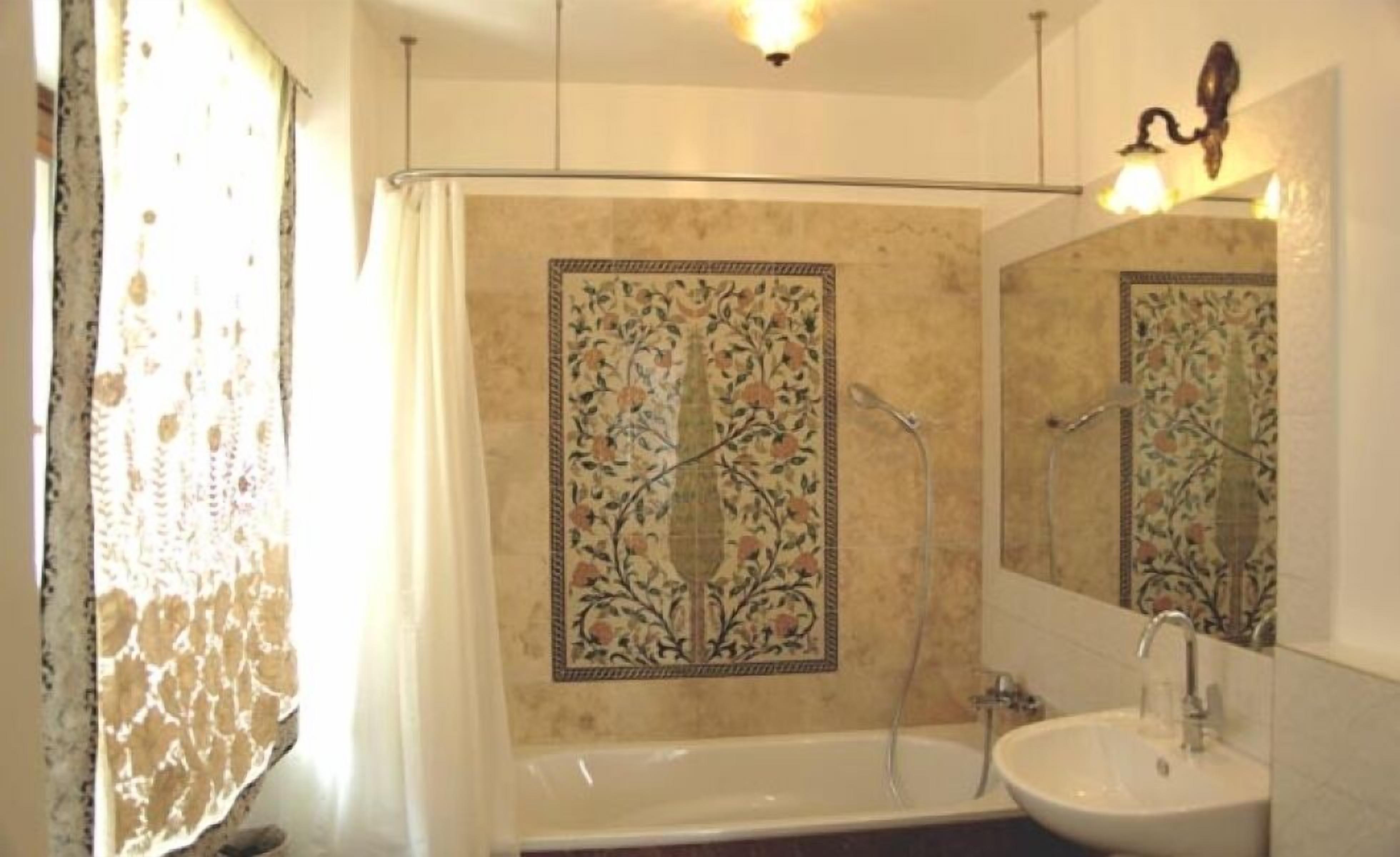 Casa de banho com banheira, pia e chuveiro.
