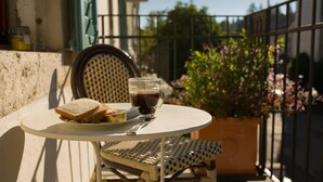 A round table with a plate of sandwiches, a glass of iced coffee, and a fork. - Guesthouse Le Locle (Le Locle)