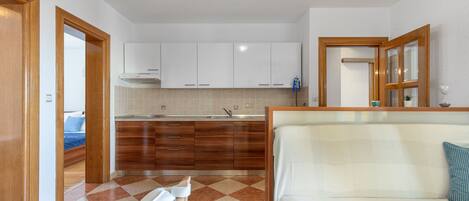 Una cocina moderna con armarios de madera, un lavamanos y una zona de comedor con banco.