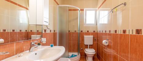A bathroom with a sink, toilet, and shower.