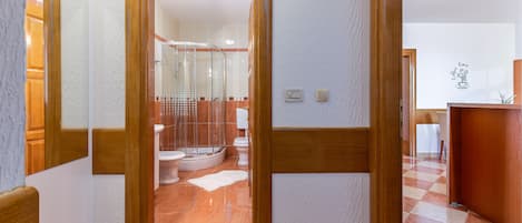Une salle de bain d’hôtel avec douche, toilettes et lavabo.