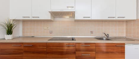 A modern kitchen with white cabinets, a stainless steel sink, and a dishwasher.