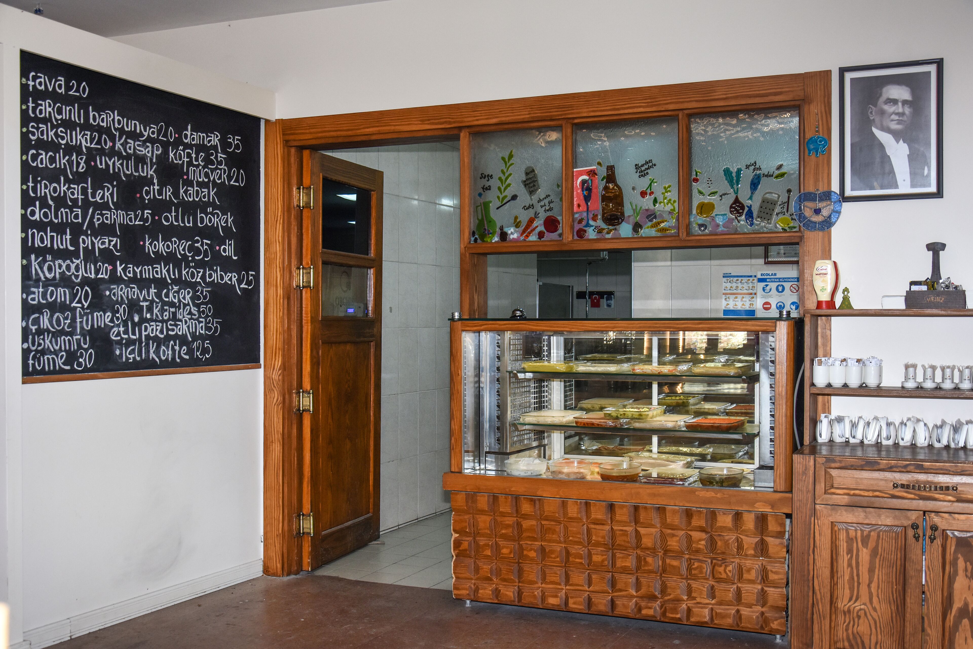 A bakery with a display case of baked goods and a chalkboard menu listing items and prices.