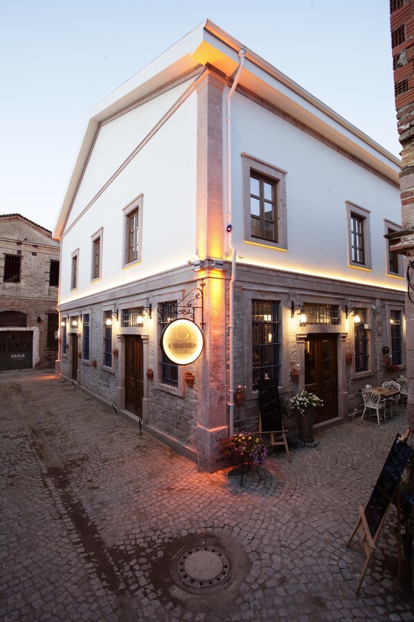 Un edificio con fachada de piedra, múltiples ventanas y un cartel que dice 'Orchestra'.