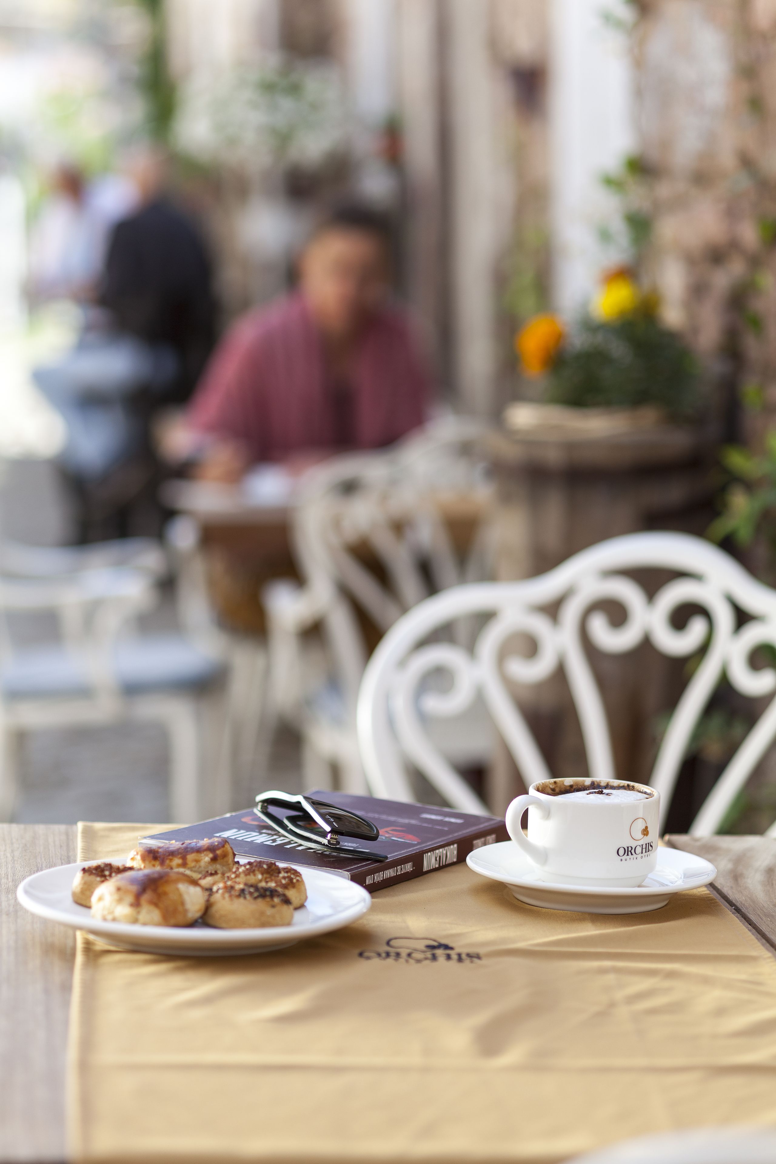 A table with a coffee cup, pastries, and a book.