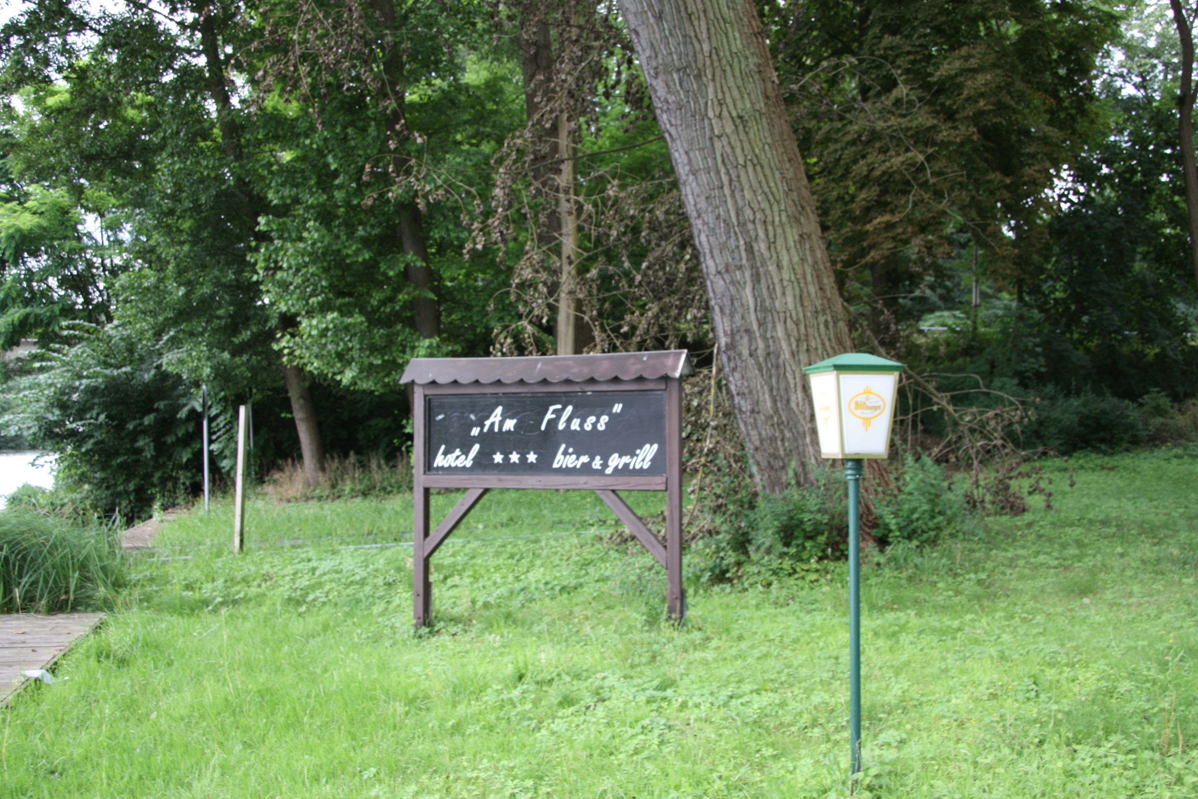 Une enseigne pour l’hôtel « Am Fluss », avec une bière et un barbecue.