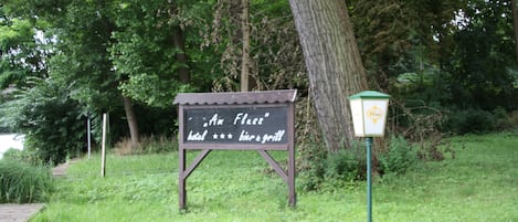 A sign for "Am Fluss" hotel with a beer and grill.