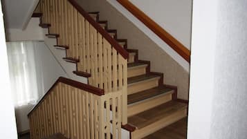 A wooden staircase with a handrail and a landing.