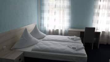 Una habitación de hotel con una cama, un escritorio y una silla.