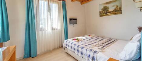 Quarto com cama, televisão, quadro e teto de madeira.