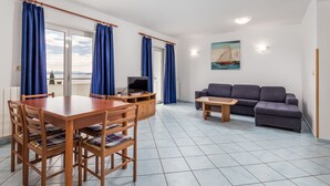 A living room with a dining table, sofa, and TV. - Apartments Gea (Moscenicka Draga)