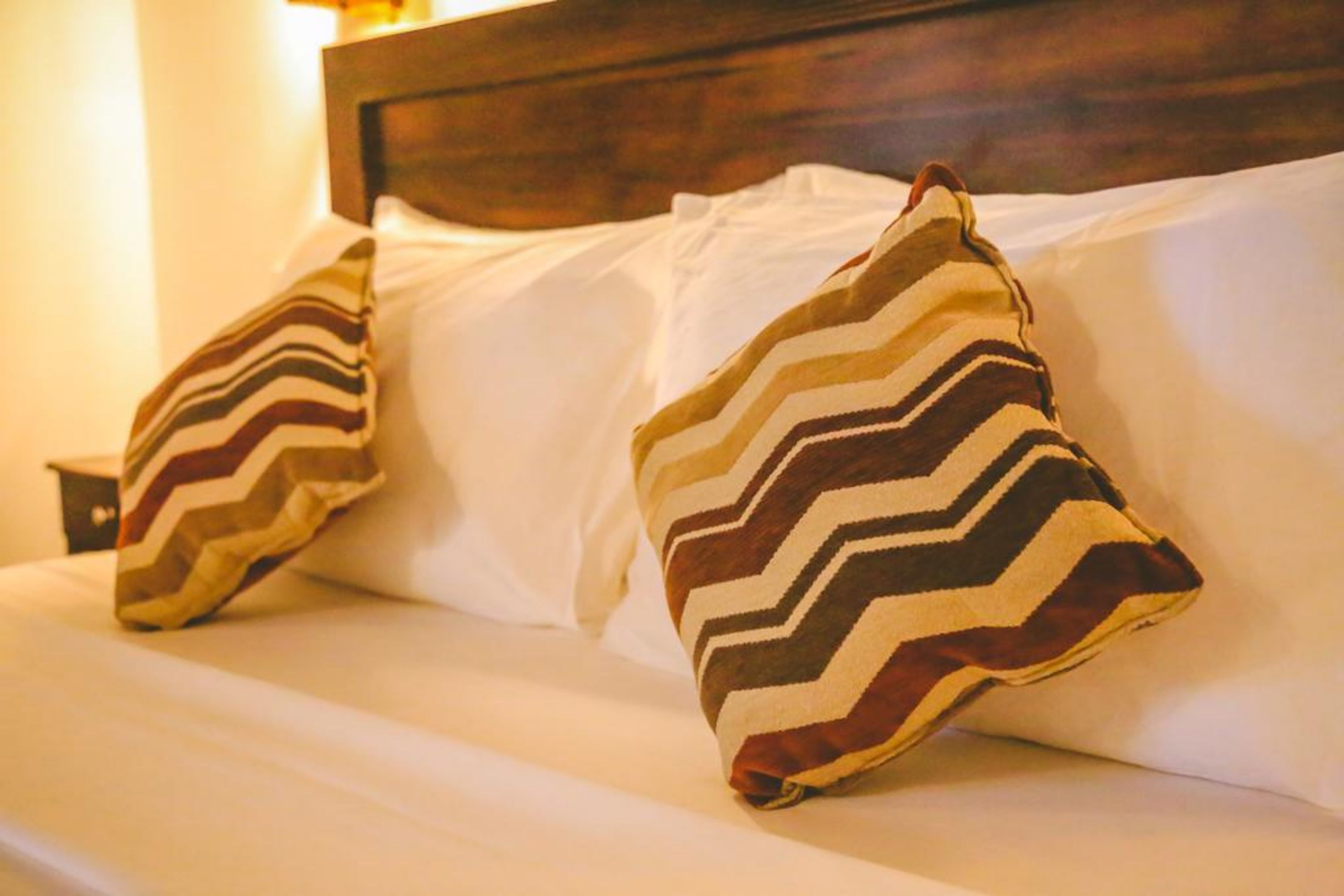Ein Bett mit zwei Kissen mit Zickzackmuster.