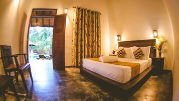 A bedroom with a bed, a chair, a nightstand, and a window with curtains.