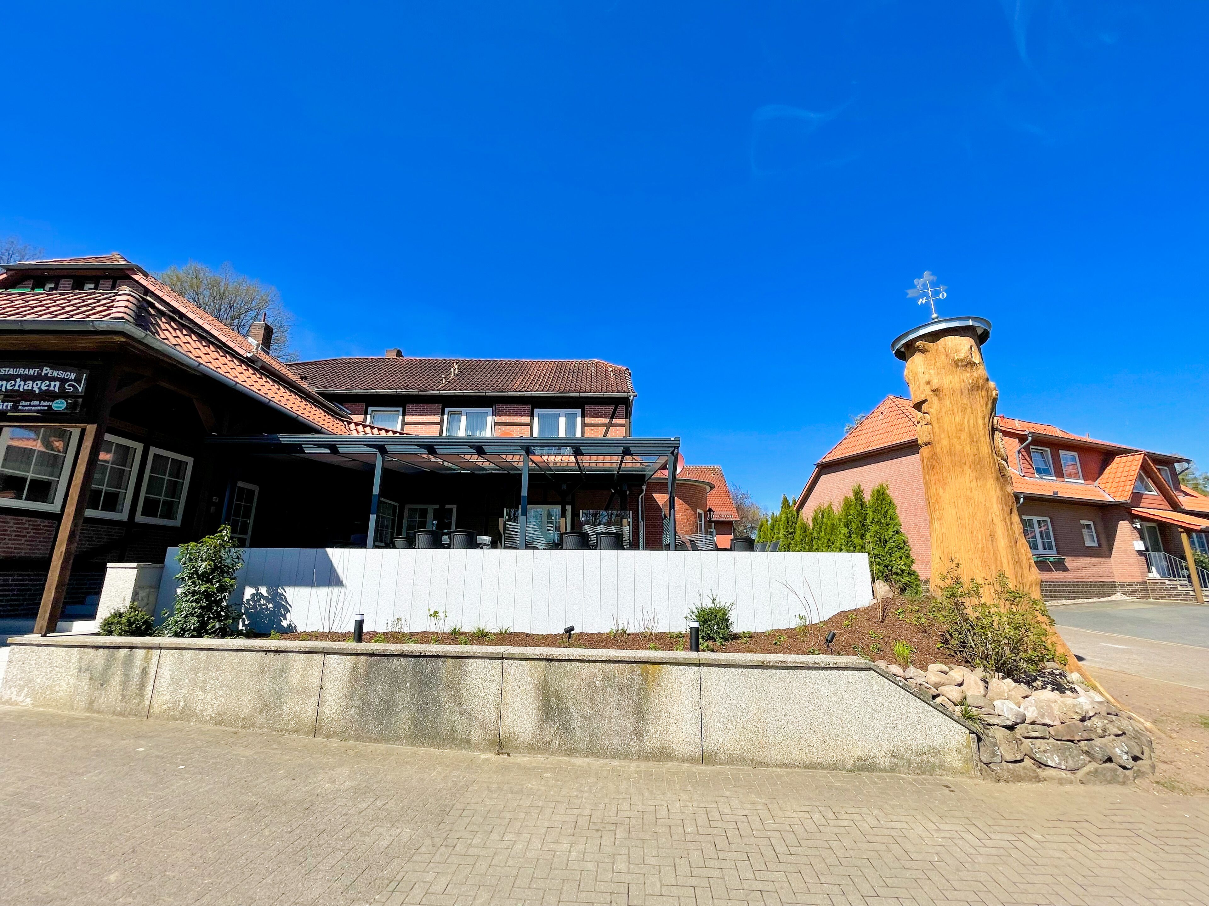 A traditional building with a covered outdoor seating area and a stone pillar.