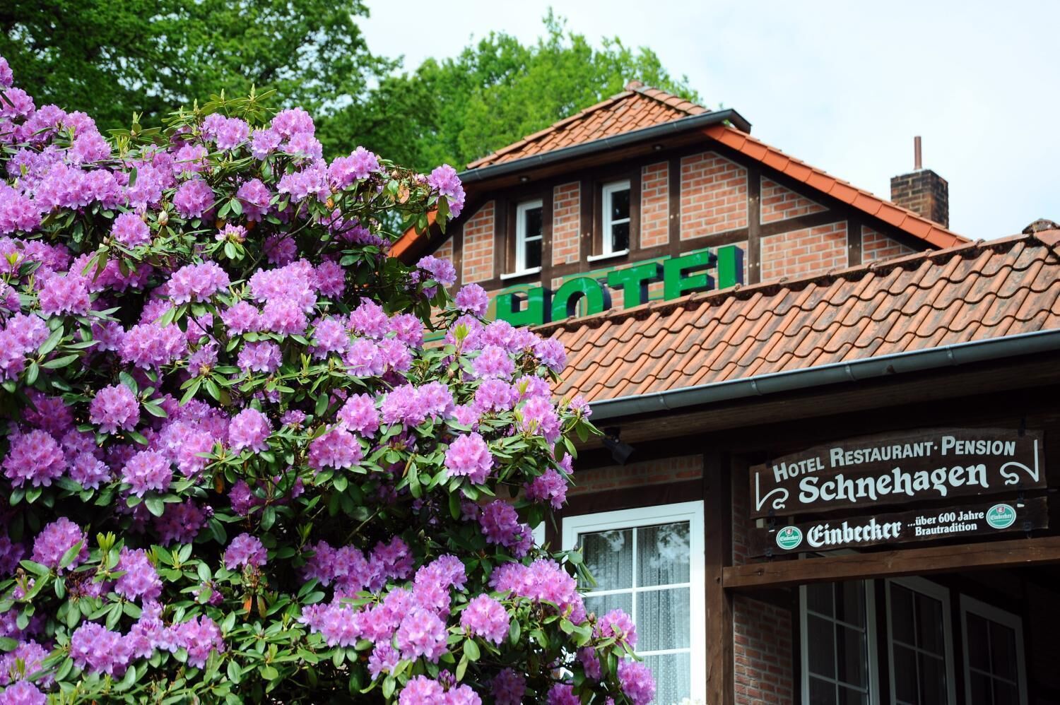 A hotel with a traditional European architectural style, featuring a brick facade and a tiled roof.