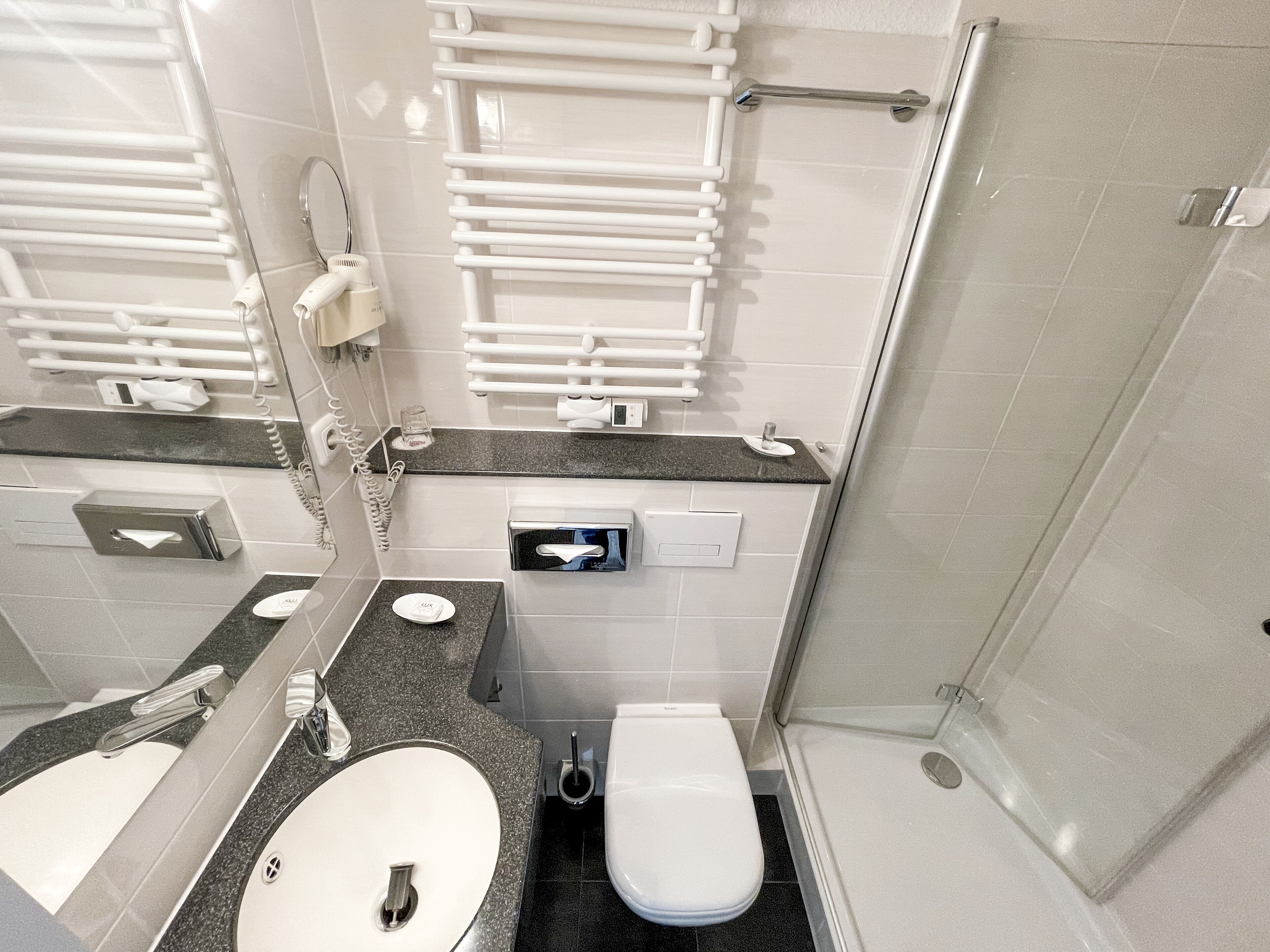 A modern bathroom with a sink, toilet, and shower.
