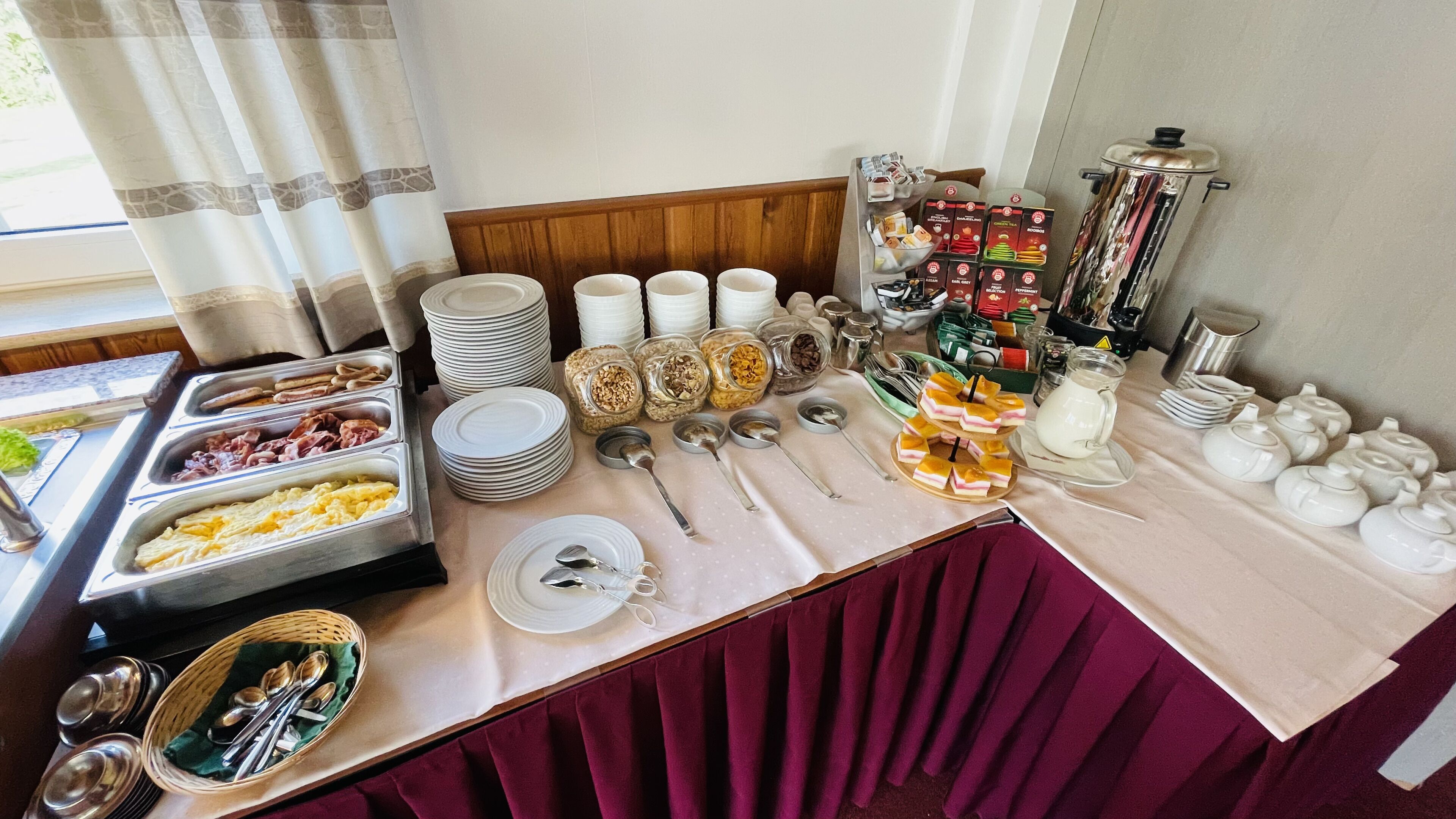 Ein reichhaltiges Buffet mit verschiedenen Speisen, Geschirr und Soßen.