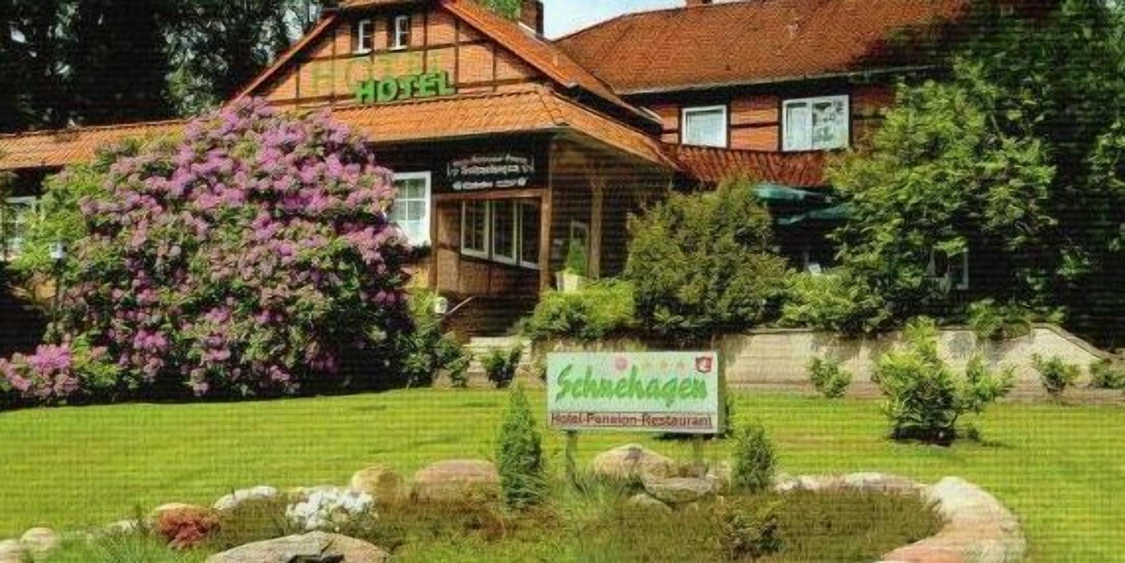 Ein traditionelles Holzgebäude mit einem Schild, auf dem „Hotel Schreckenberg Hotel Restaurant“ steht.