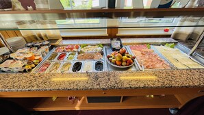 A buffet with various food options including fruits, cheeses, and meats. - Hotel Schnehagen (Bad Fallingbostel)