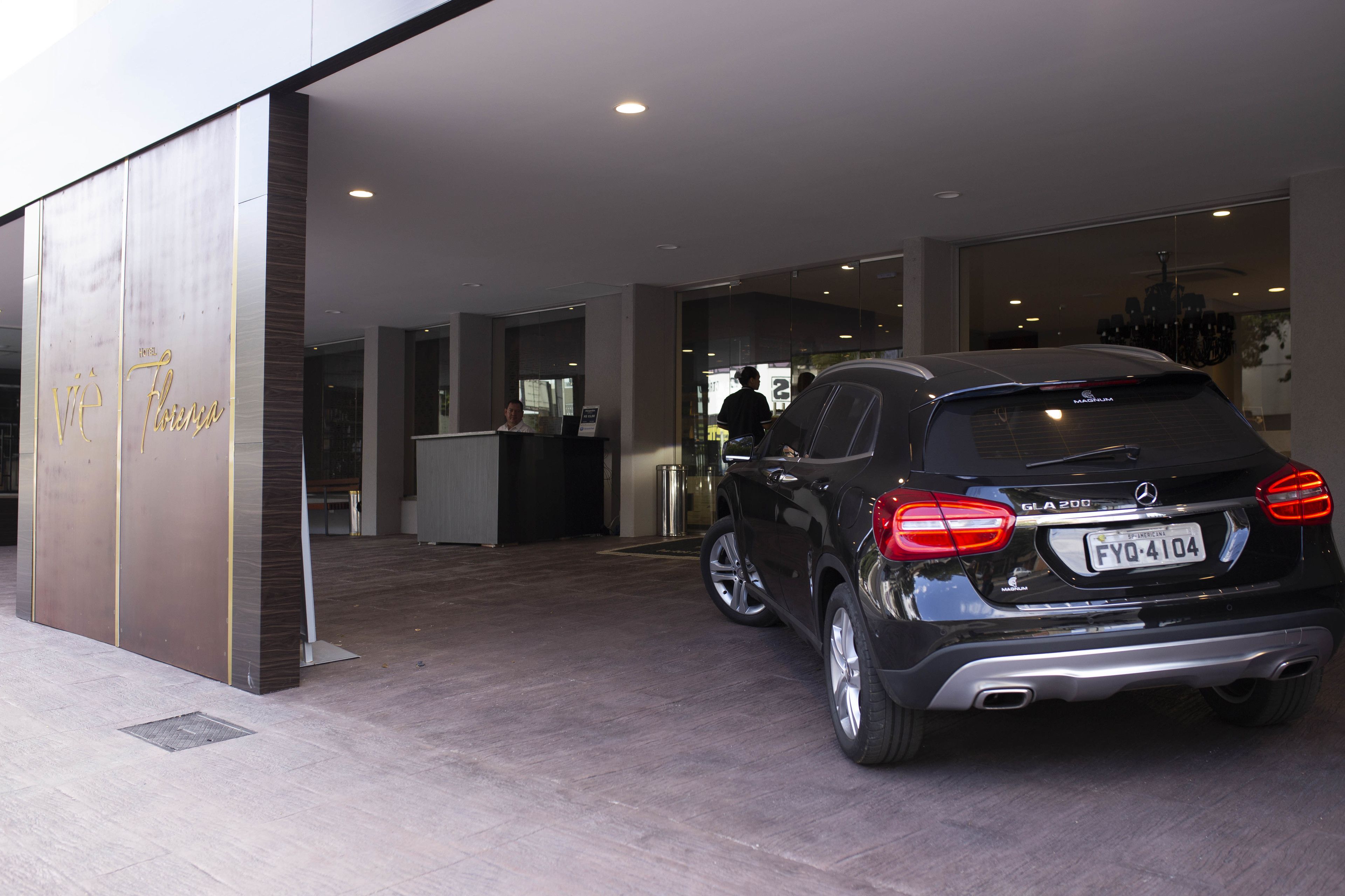 A black Mercedes-Benz GLA 200 parked in front of a building with a sign that reads "VIA Florence."