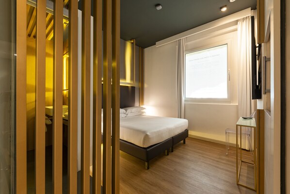 Een moderne slaapkamer met een bed, een klein tafeltje en een raam.