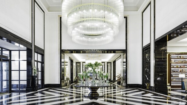 A grand lobby with a large chandelier, a black and white checkered floor, and a central plant arrangement. - Fairmont Amman (Amman)