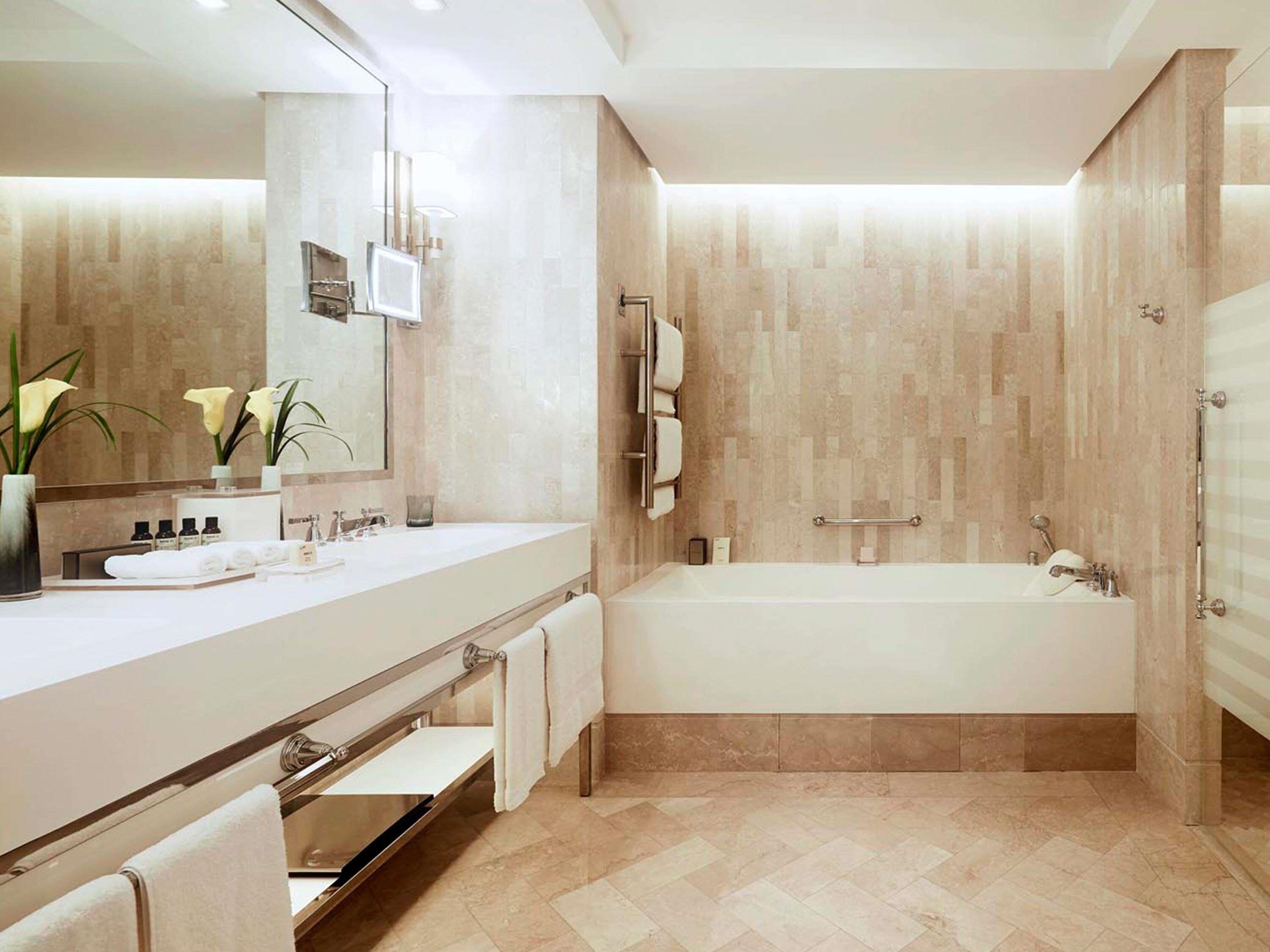 A modern bathroom with a large bathtub, a vanity with a mirror, and a toilet.