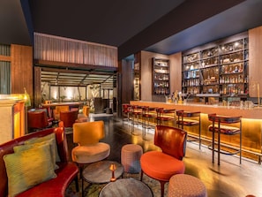 Un espace bar avec des sièges et un présentoir bien garni de boissons alcoolisées.