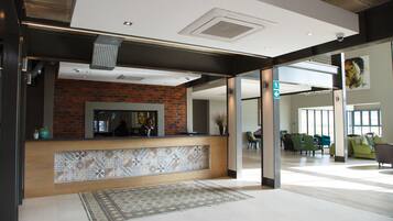 A reception area with a brick wall, a tiled counter, and a patterned rug.
