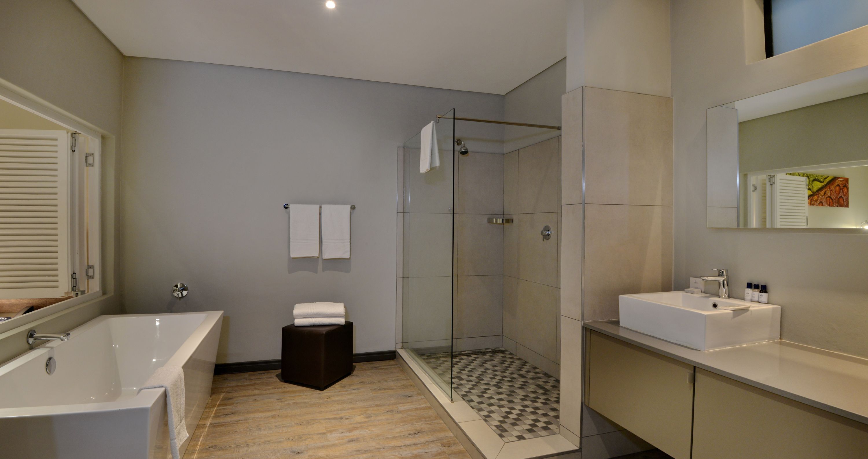 Un baño moderno con bañera, ducha y tocador con espejo.