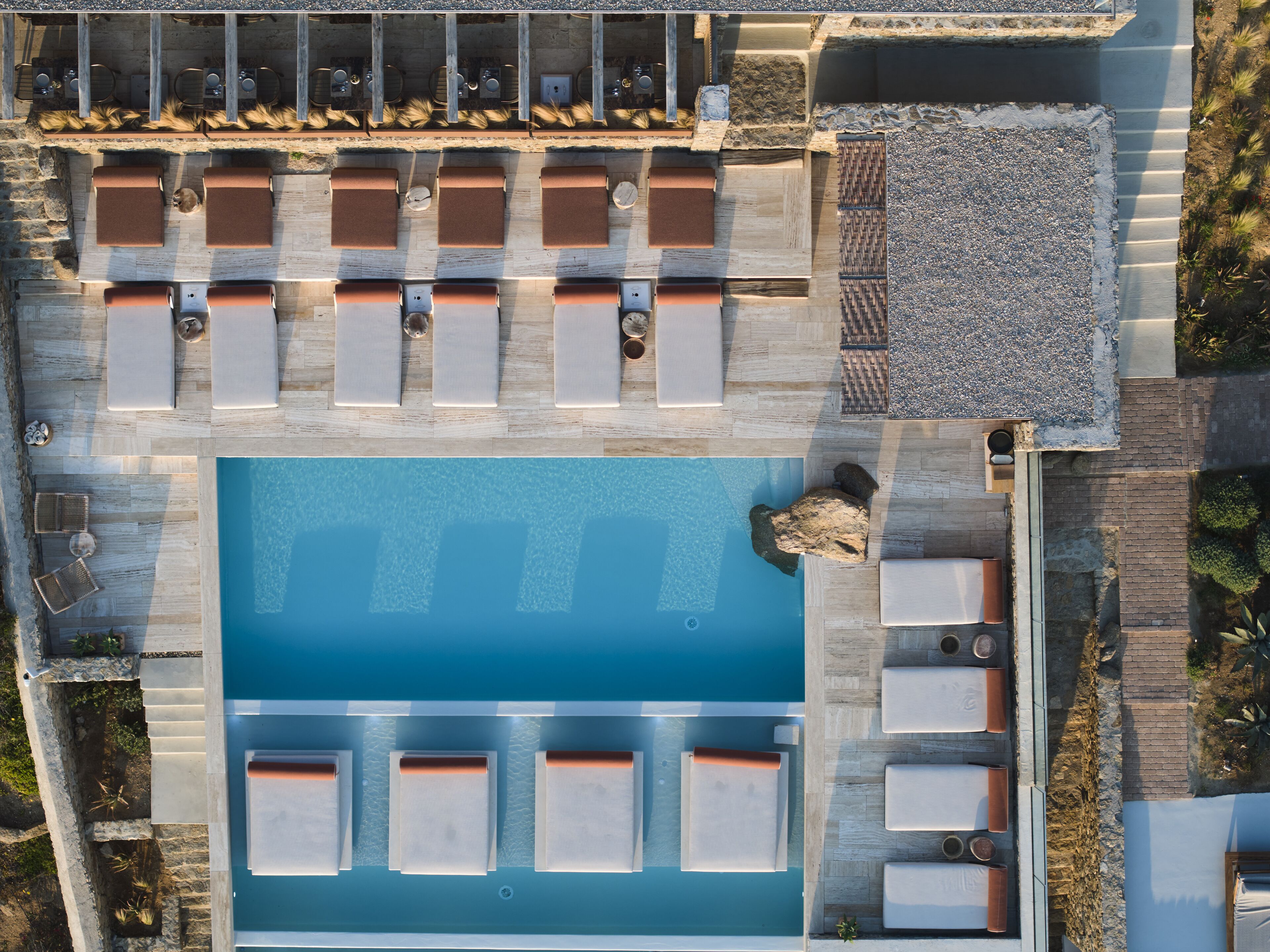 An aerial view of a pool area with multiple lounge chairs and a central swimming pool.