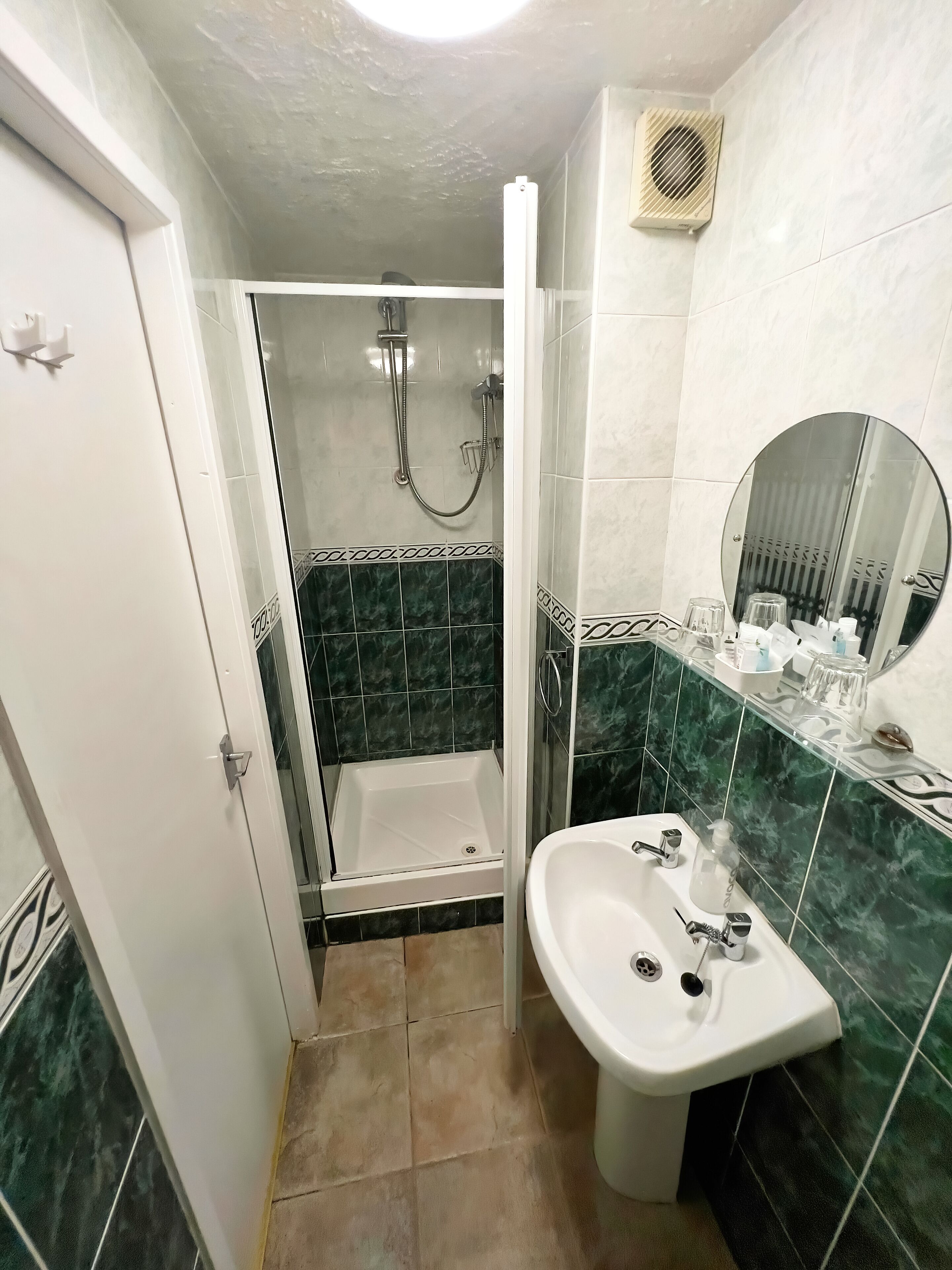 Un bagno con doccia, lavandino e specchio.