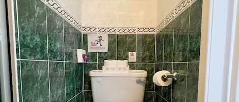 A bathroom with a toilet, a sink, and a towel rack.