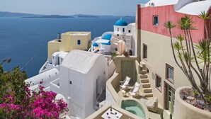 A coastal building with a pool, white and blue domed structures, and a view of the sea. - Cosmoia Cave House (Santorini)