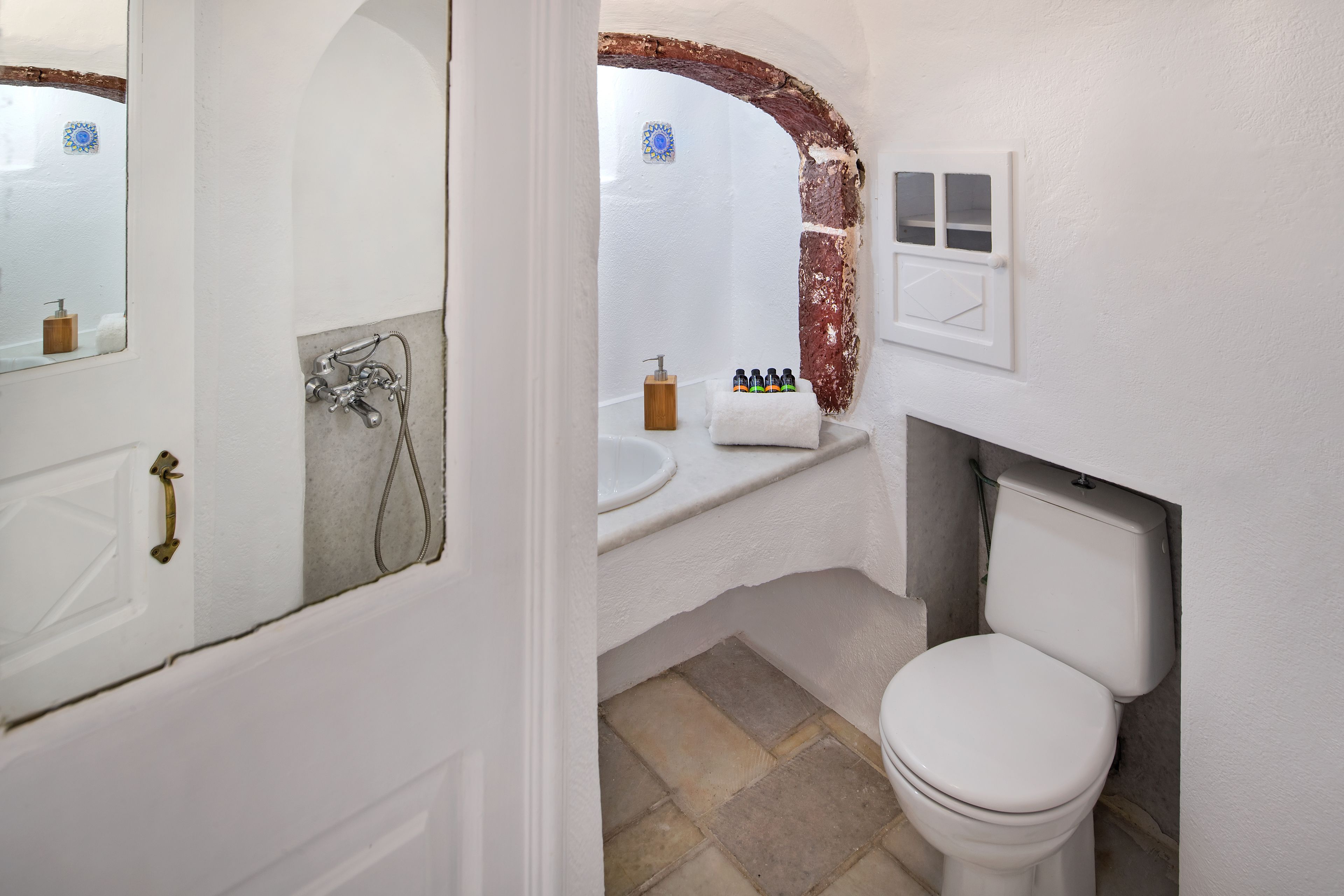 A bathroom with a white sink, a toilet, and a shower area.