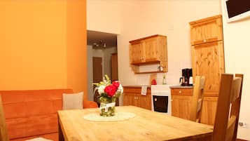 Un comedor con una mesa de madera, un jarrón con flores y una silla de madera.