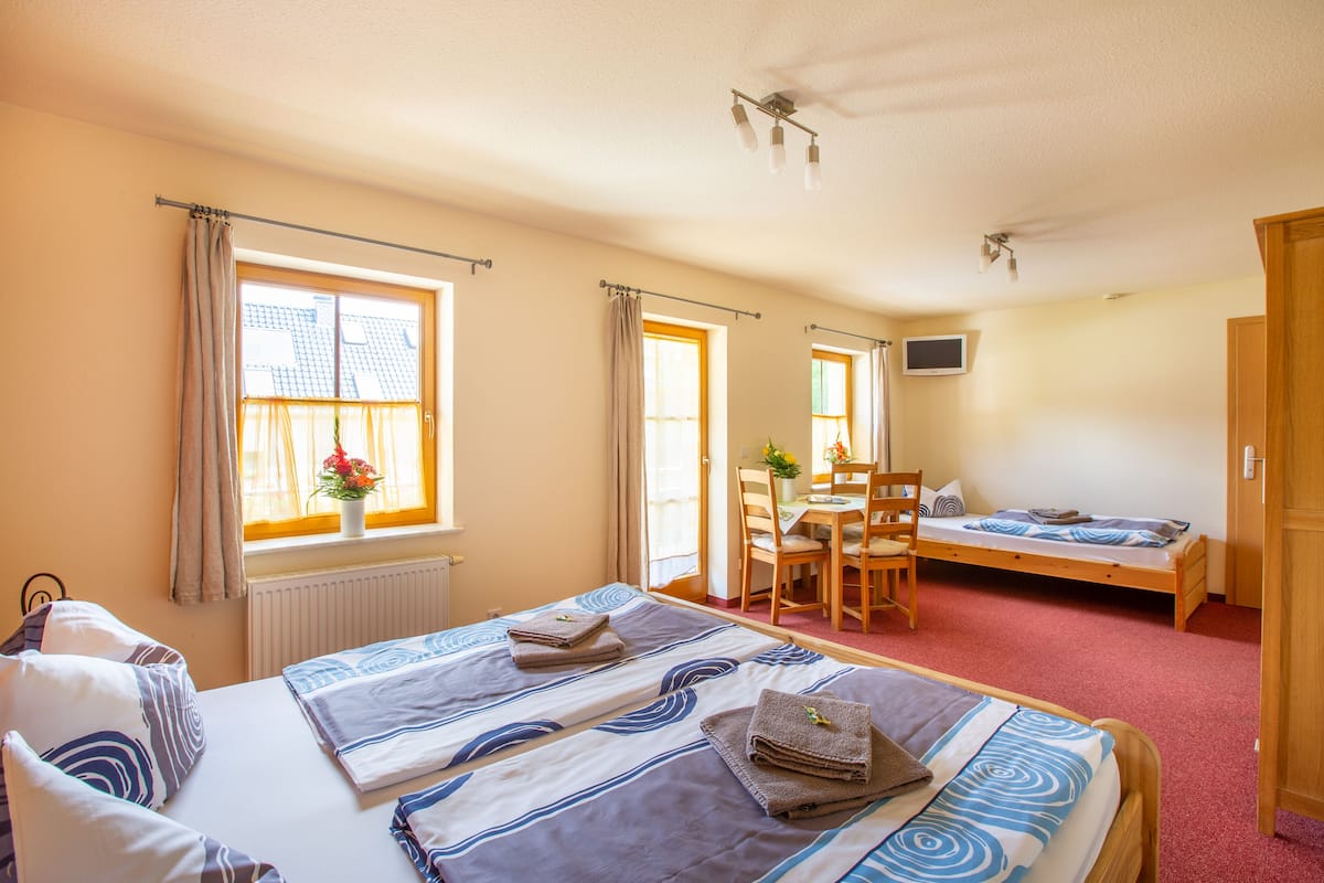 Une chambre d’hôtel avec deux lits, un coin repas et un téléviseur.