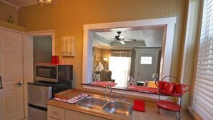 A compact kitchen with a microwave, a sink, and a red tray stand. - Inn at Park Spring (Portland)
